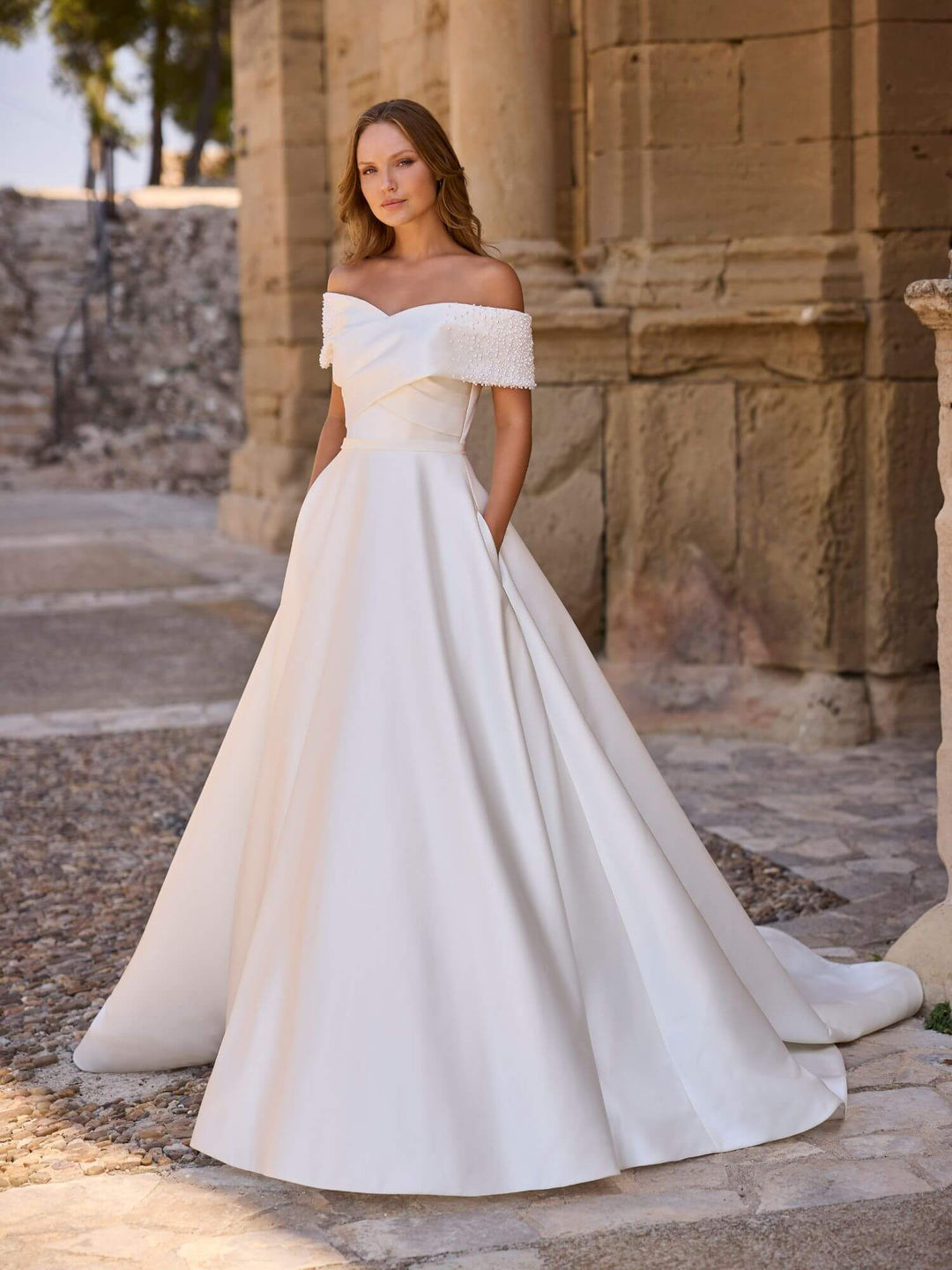 Brudekjole 63036 – fuld visning med perledetaljer, off-shoulder snit og klassisk A-line fald.