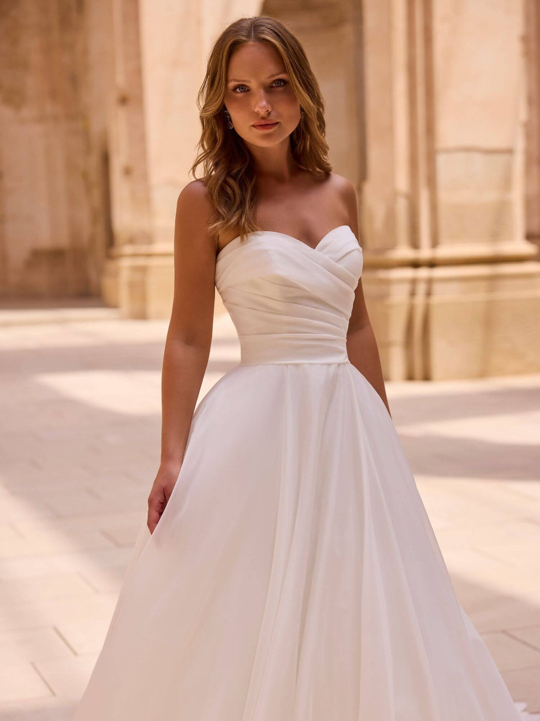 Brudekjole 63048 – close-up af draperet sweetheart corsage og chiffon-fald.