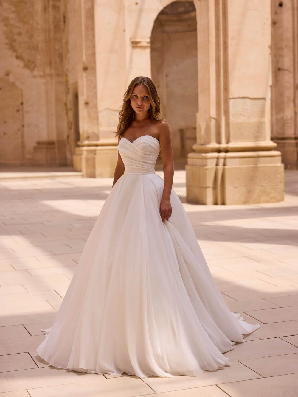 Brudekjole 63048 – frontvisning i fuld figur med elegant fald og stropløs overdel.