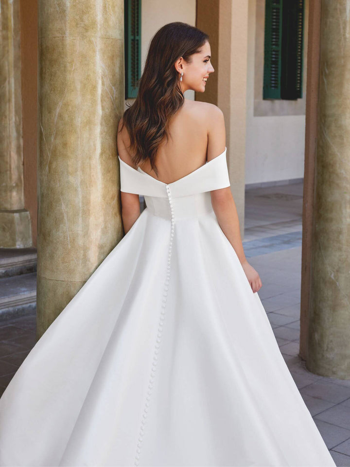 Off-shoulder brudekjole i Stretch Mikado med en smuk sløjfe, der giver et moderne og feminint look.