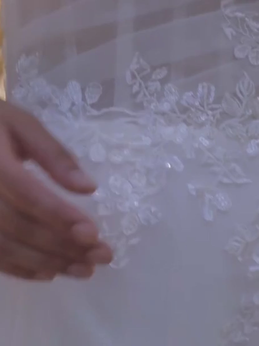 Oplev den elegante A-line brudekjole i organza med sparkle tulle underlag, sweetheart-udskaering og aftagelige off-shoulder stropper. En romantisk og fleksibel brudekjole med tidløs elegance.

