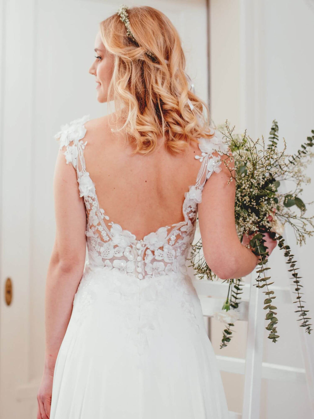 Detalje af Sanna Lindstrøm SL1019X Gina brudekjole – blomsterapplikationer og glitrende 3D-blonder.